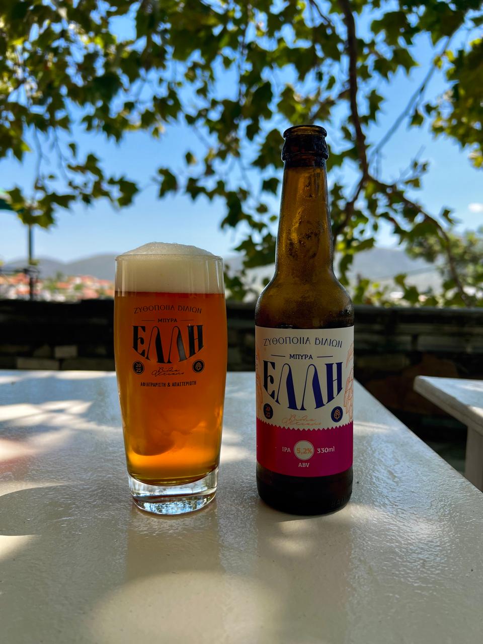 ΕΛΛΗ IPA με ποτήρι μπύρας σε τραπέζι κάτω από δέντρα